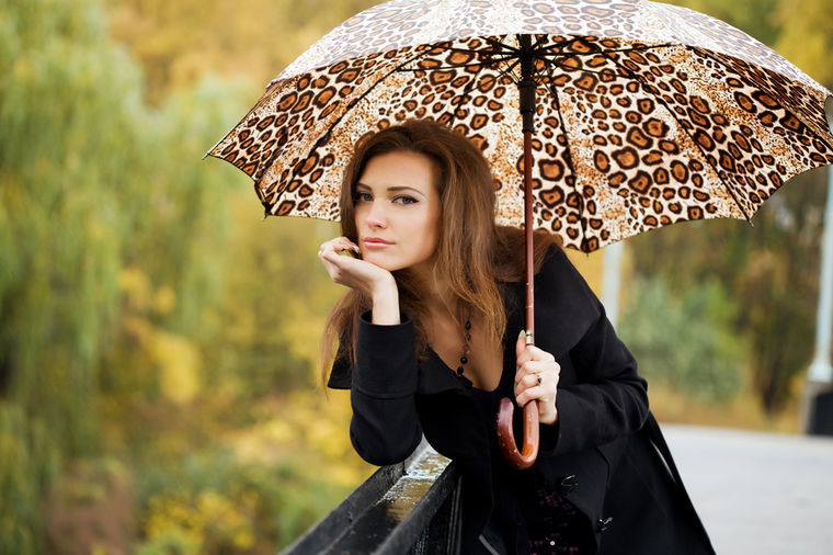 Chica con un paraguas con un estampado de leopardo
