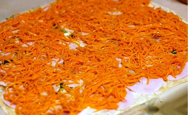 Рулет из лаваша с корейской морковкой и ветчиной перед сворачиванием ролла