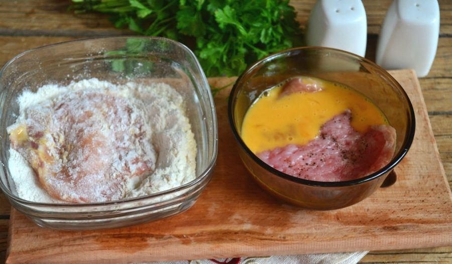 Свинные отбивные в процессе обработки яйцом и мукой перед жаркой