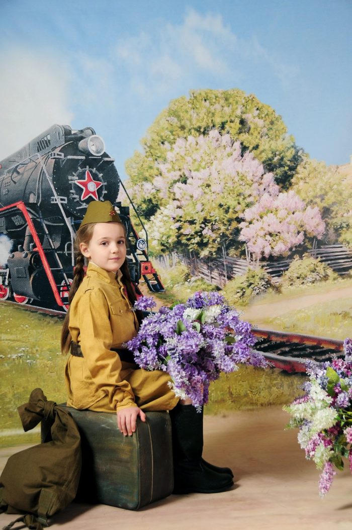 Цветы играют роль реквизита в детской фотосессии приуроченной к 9 мая