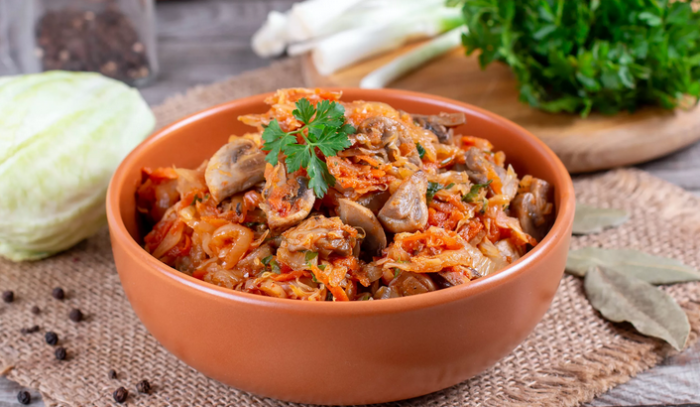 Тушеная капуста в кастрюле с курицей и грибами