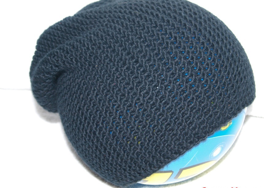 Dark gray hat tied with knitting needles across