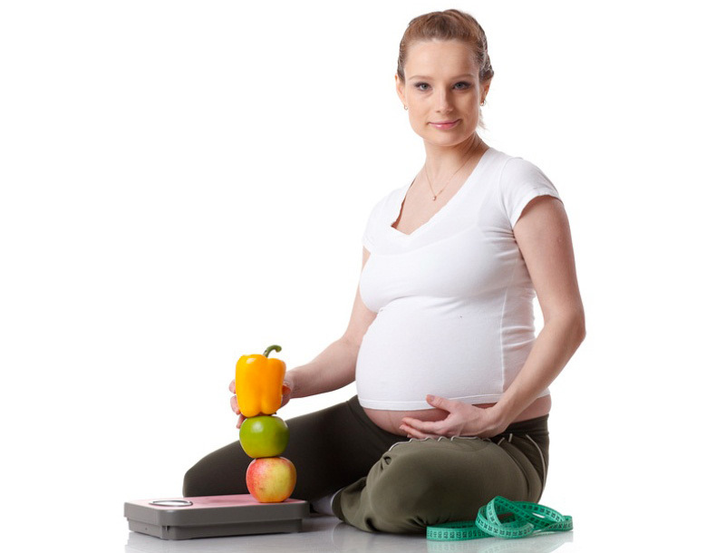 Беременная женщина с весами и едой