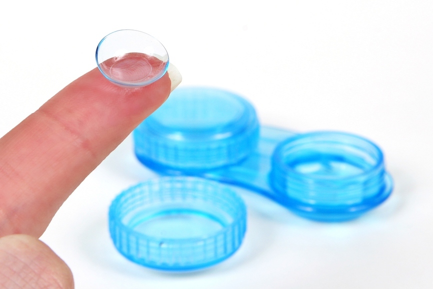 On the person’s finger, the lens before dressing, extracted from the container