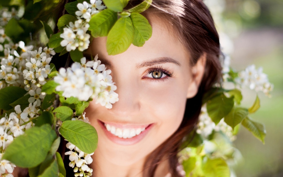 Mujer sonriente entre flores de cereza