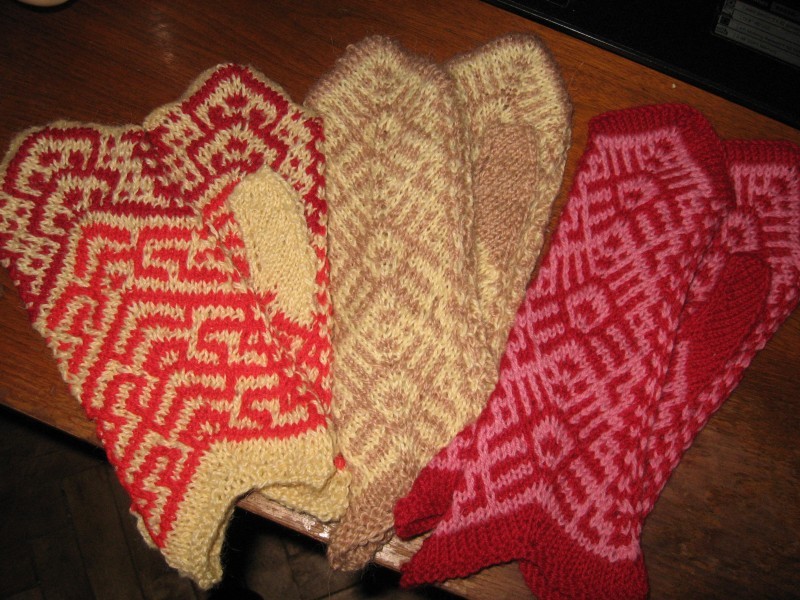 Several pairs of knitted mittens with lazy patterns