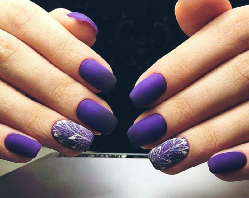 L'idée de conception violette sur les ongles avec du vernis mat