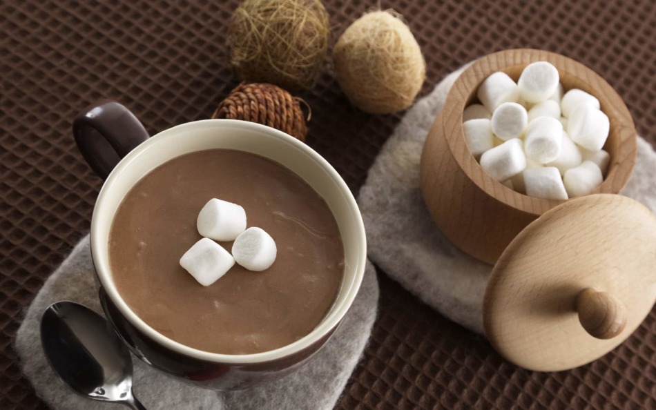 On the table a cup with aromatic cocoa and sugar bowl