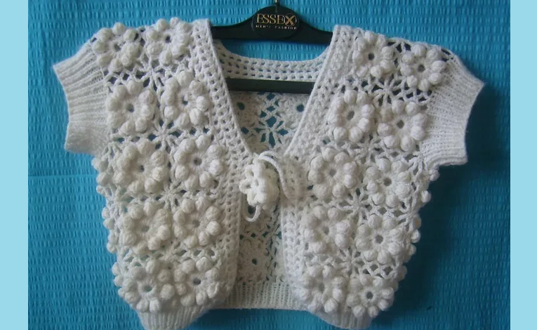 Knitted children's sleeveless jacket with a crochet 