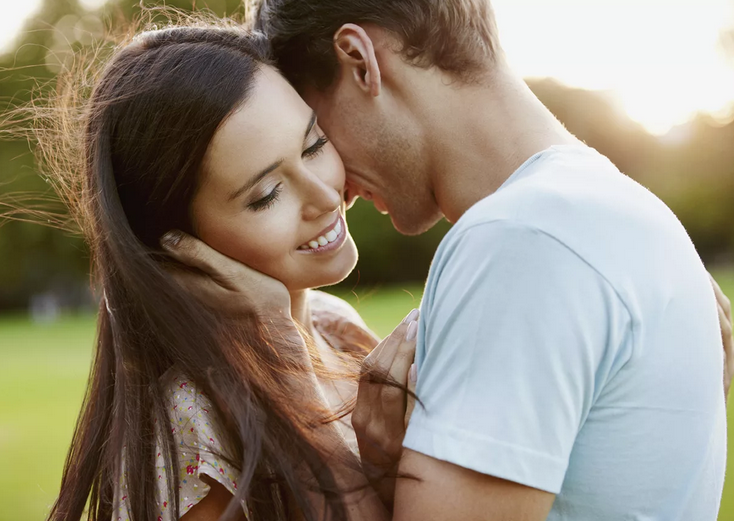 Il ragazzo tocca, accarezza il viso della ragazza con le mani