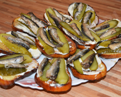 Sands avec Sprats: recettes. Comment faire cuire de délicieux sandwichs avec des sprats avec un œuf, du pain noir frit, un pain, des tomates, du concombre, du citron, de l'ail?