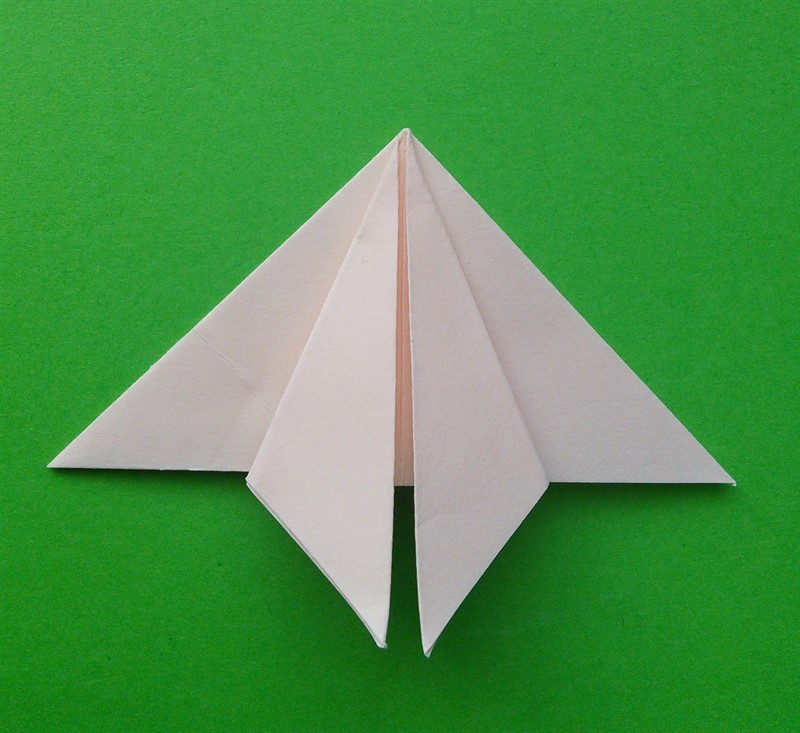Egy papírlapot a fektetéshez egy háromszögbe kell összecsukni, majd a következő szögeit be kell tekerni