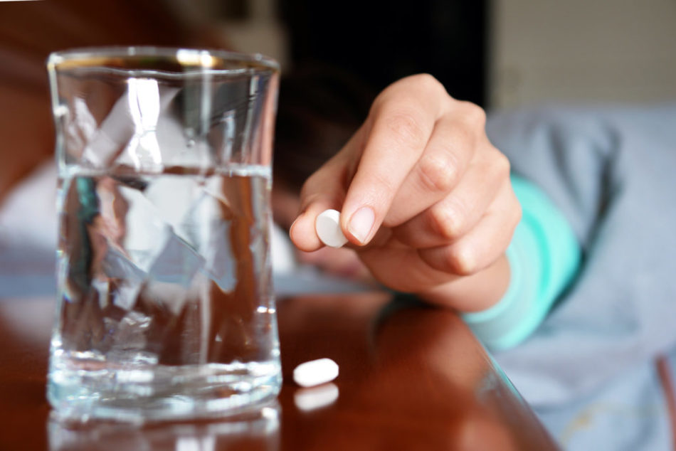 A lány a kezében tart egy tablettát anti -zealsant -tól, hogy könnyes legyen