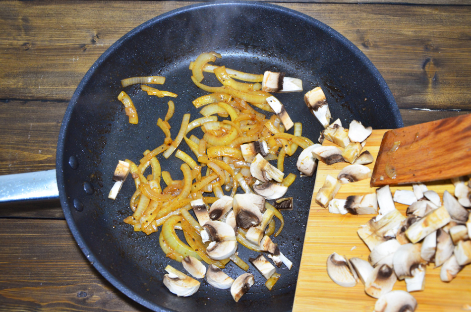 Les champignons avec oignons sont frits après la viande