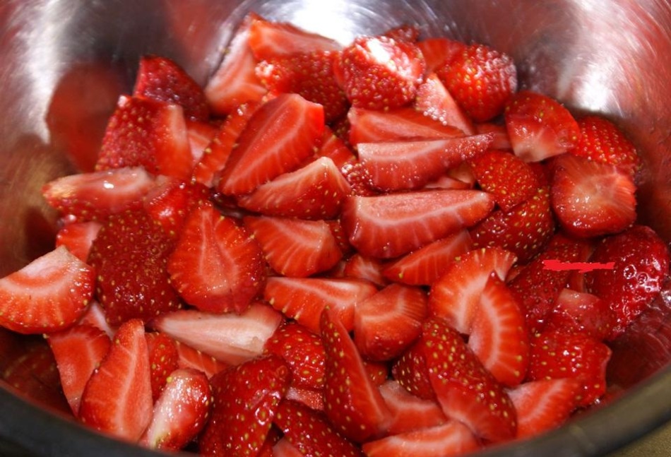 Κόψτε σε ένα κύπελλο πολλαπλών περιβλήτων κόβει τις φράουλες πριν από το μαγείρεμα μαρμελάδα