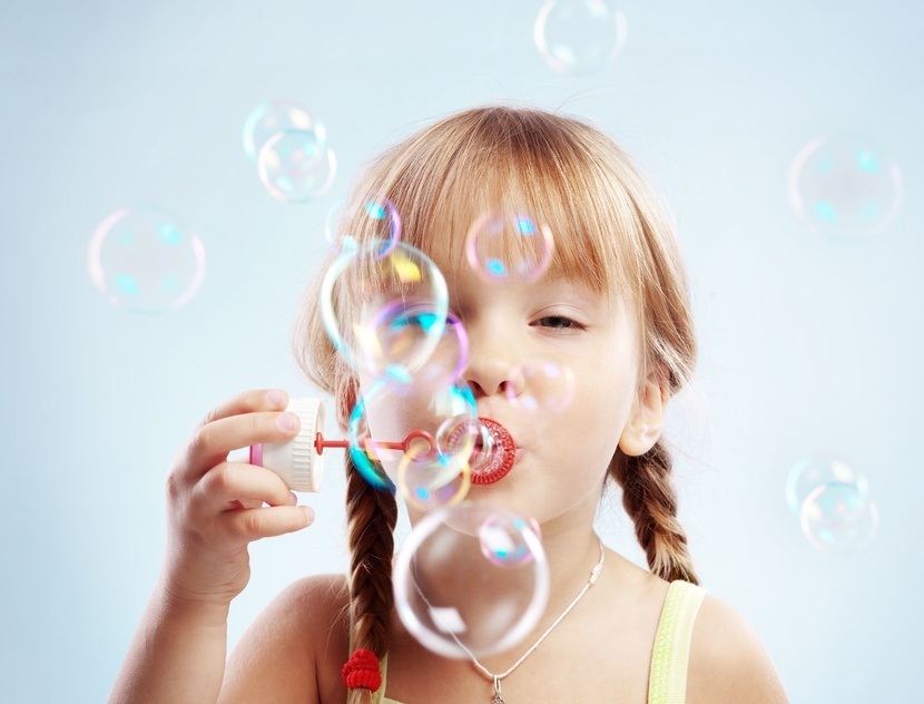 Девочка выдувает крепкие мыльные пузыри из домашнего раствора
