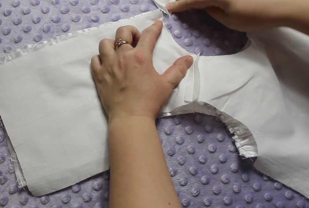 We roll up and sew together all the details of the top of the dress