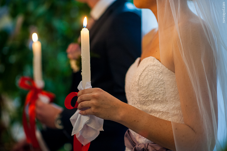 Lilin pernikahan memegang muda di tangan mereka