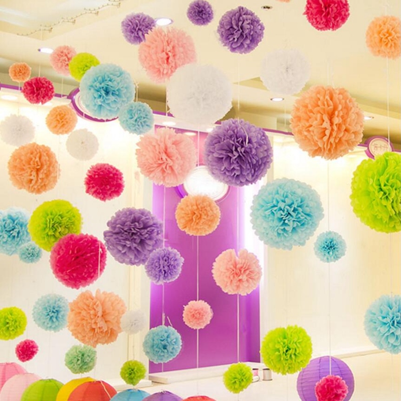 Multi -colored pompons from fastened paper hang in the room