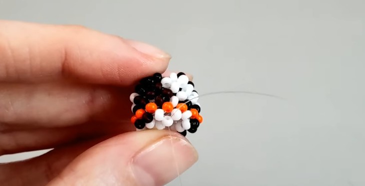 Stretch the end of the fishing line through one brown and one white beads