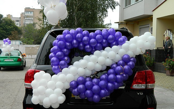 Exempel på dekoration av bröllopsmaskiner är ett hjärta med en pil med ballonger