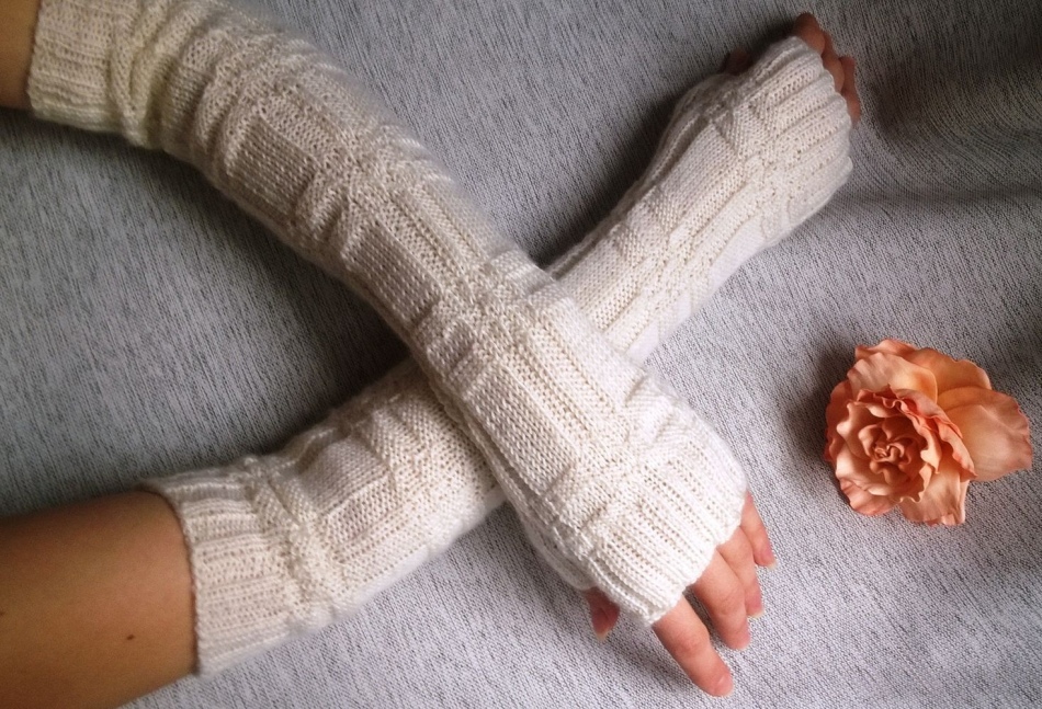 In the hands of a girl, knitting down long gloves without fingers