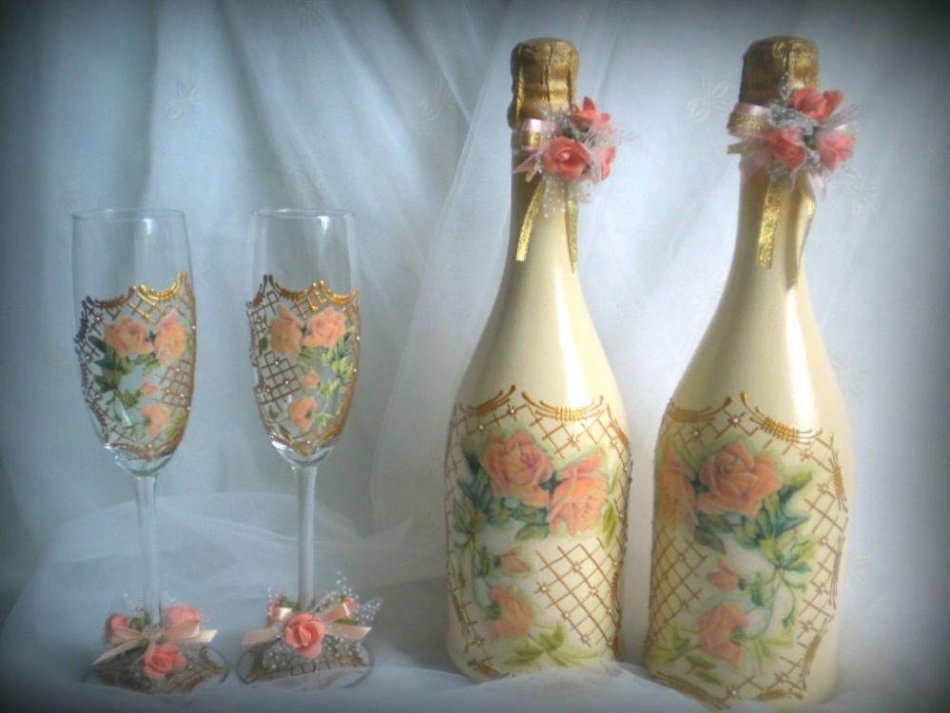 Bottles and glasses decorated with ribbons and flowers using decoupage technique