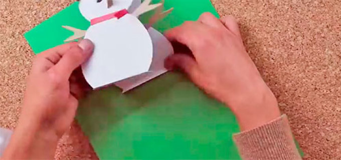 Фиксируем с помощью клея одну половинку снеговика на открытке