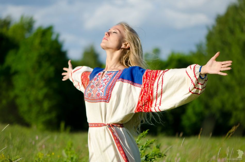 Το Slavnyak σε εθνικά ρούχα συναντά την ανατολή του ηλίου κατά τη διάρκεια του καλοκαιριού ηλιοστάσιο