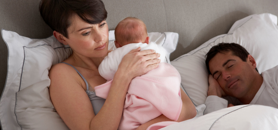 Müde junge Mutter hält das Baby in ihren Armen