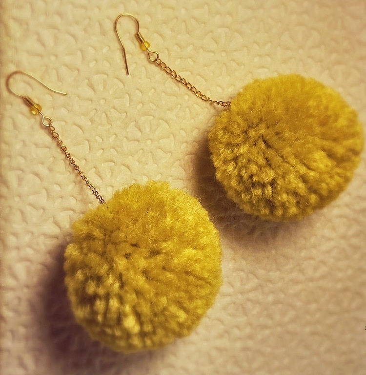 Yellow homemade earrings from pompons