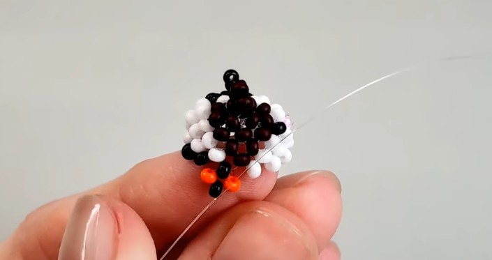 Stretch the fishing line through the orange bead