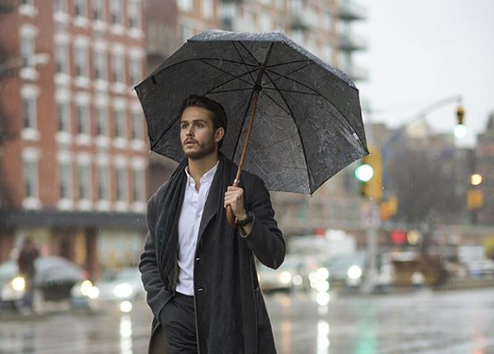 Ein Mann mit einem Regenschirm an einem regnerischen Tag