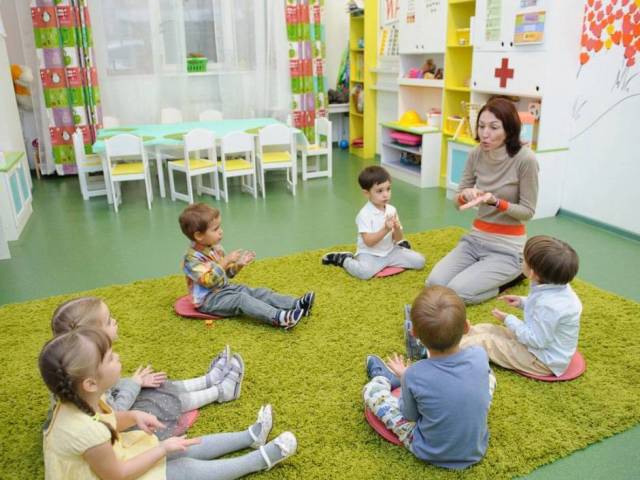 Der Verlauf des jungen Kindergartens: Der Lehrer erzählt, was das Kind tut, während die Eltern bei der Arbeit sind