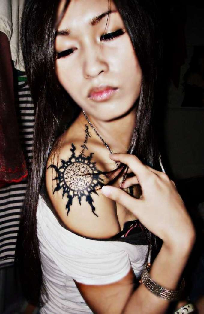 Tattoo on the shoulder in the form of the Celtic sun