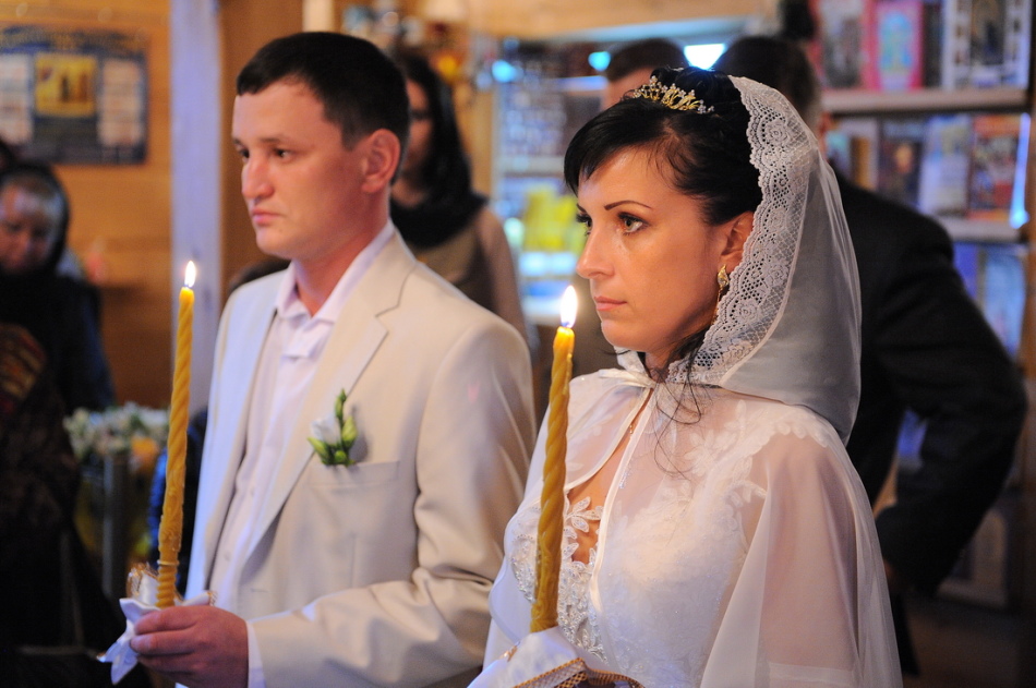 Az ifjú házasok komoly arcai az esküvő alatt