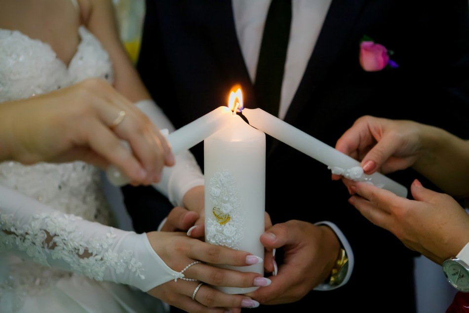 Свадебная свеча с белыми цветами и золотыми кольцами