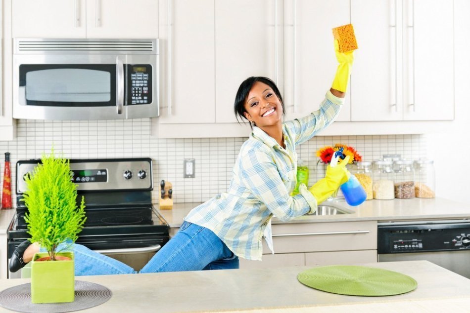 Улыбчивая девушка убирает на кухне по системе флай леди