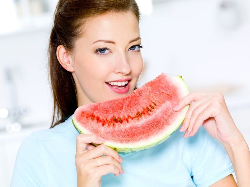 The girl is happy to eat a slice of watermelon