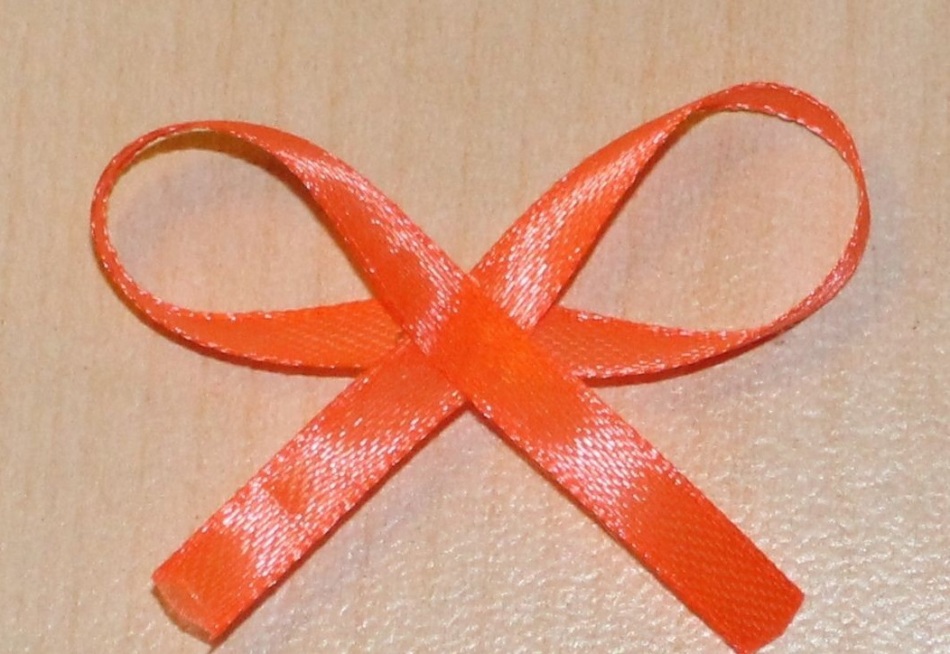 Gluing the tape in the form of a bow for decoupage of a ball
