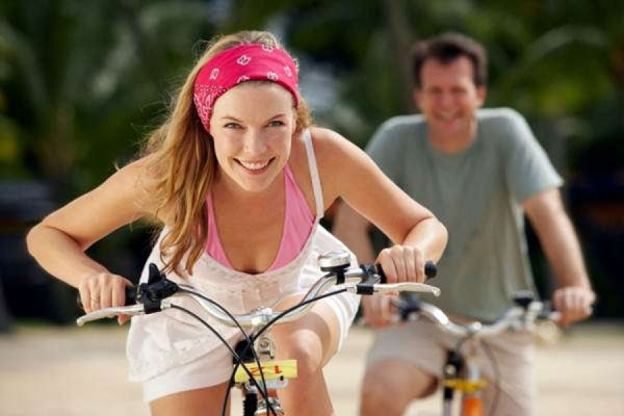 Le blonde souriant se déplace sur un vélo et ne ressent pas de douleur dans les genoux