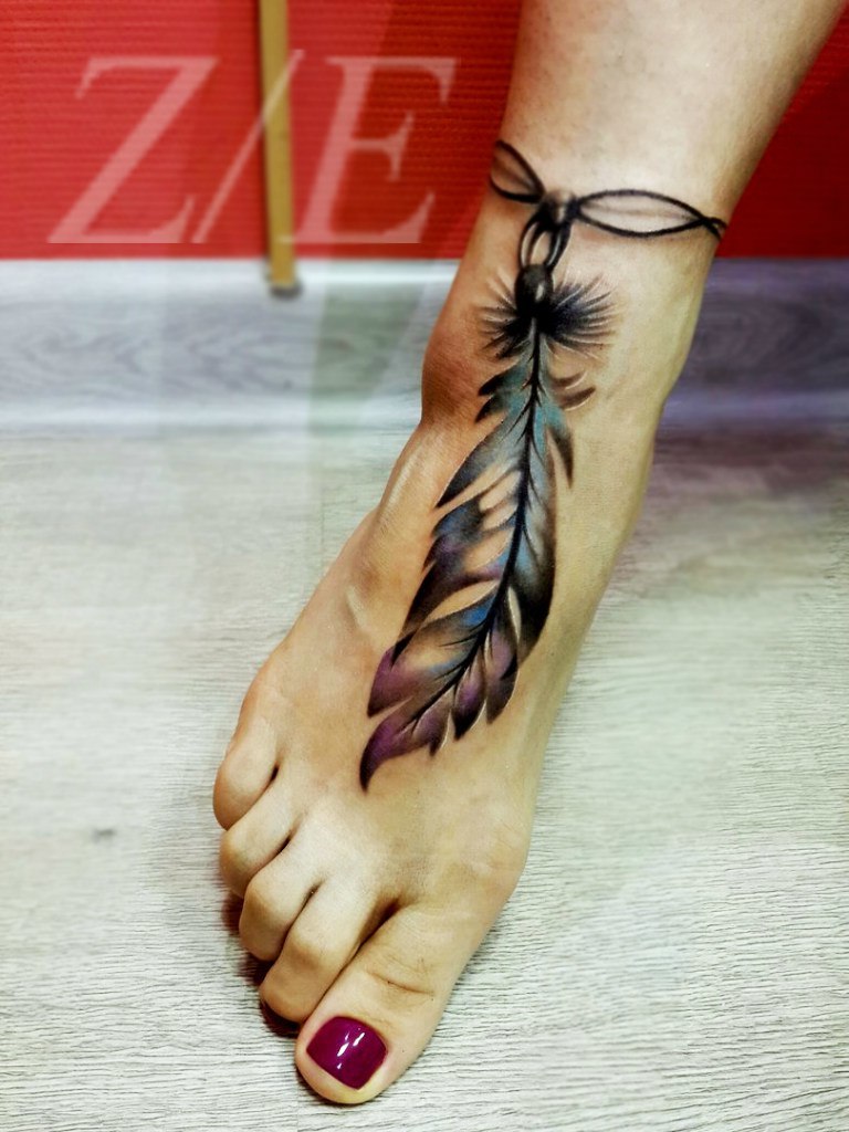 Такое перо на цепочке - частая тема татуировок на стопе