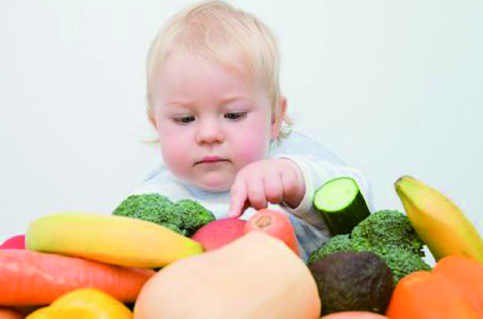 Kid considers vegetables and fruits
