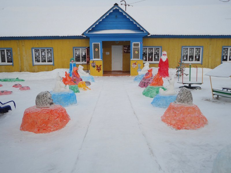 Figuras de nieve de color cerca de un jardín de infantes