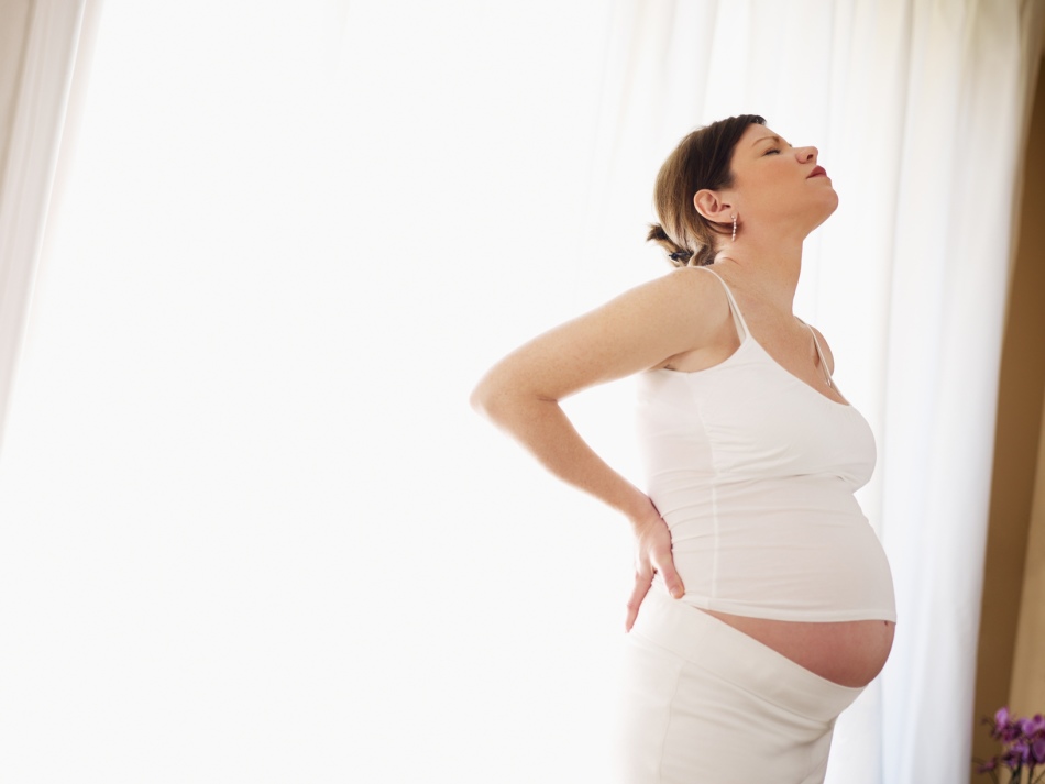 La femme enceinte tient sur le bas du dos