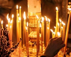 What hand should a candle be in the church?