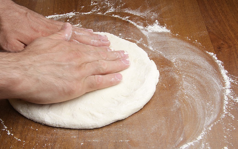 A pizza cake is formed only manually, without using a rolling pin!