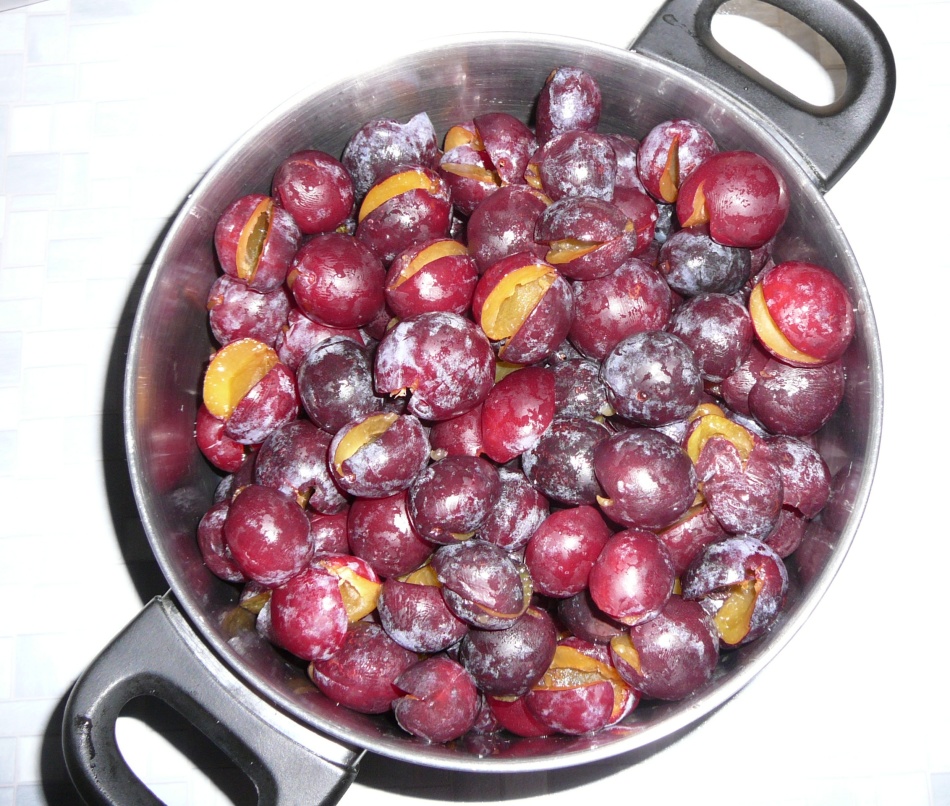 Fragrant plums without bones are folded in a pan to prepare acute sauce for the winter