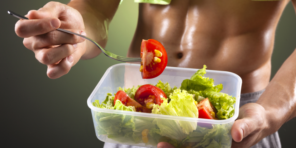 A man eats a vegetable salad after training