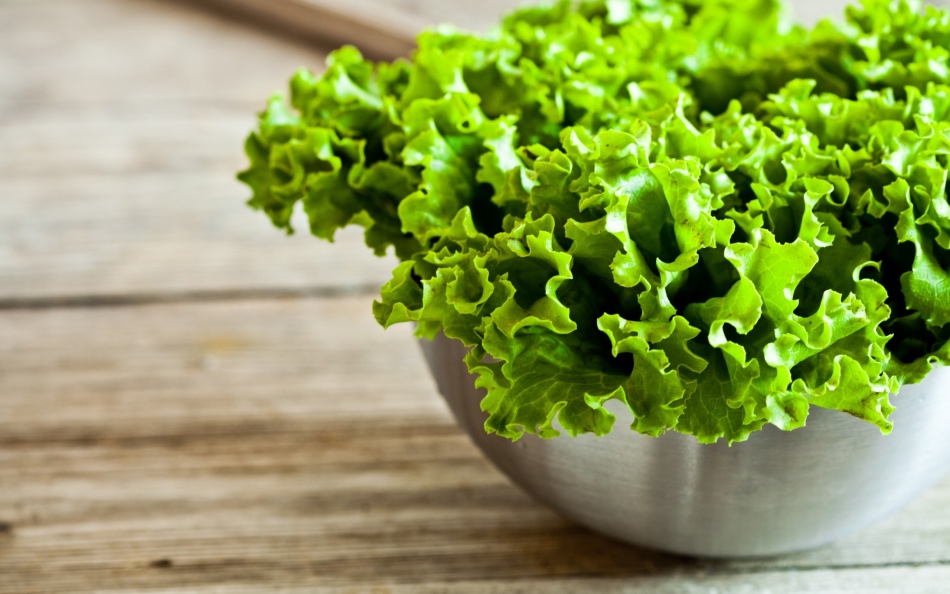 Daun salad hijau yang dipilih dalam mangkuk di atas meja sebelum acar